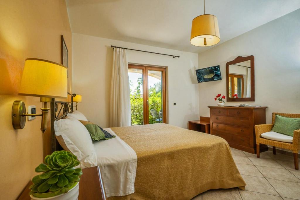 a bedroom with a bed and a dresser and a mirror at Agriturismo Parmenide in Castelnuovo Cilento