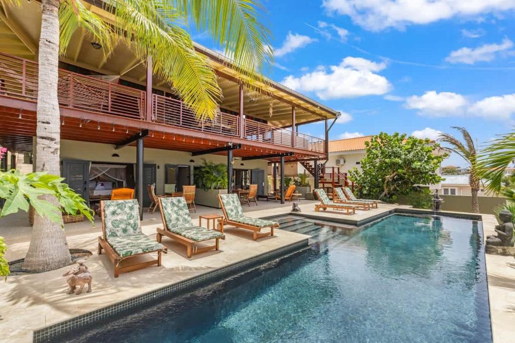 a resort with a swimming pool and lounge chairs at Bali Suites - Ubud Suite in Willemstad