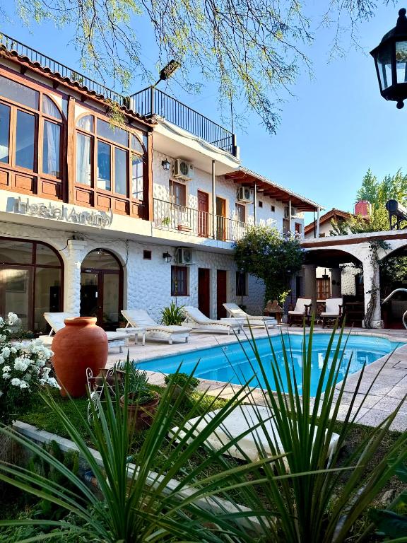 a house with a swimming pool in front of it at Hostal Andino - Adults Only in Cafayate