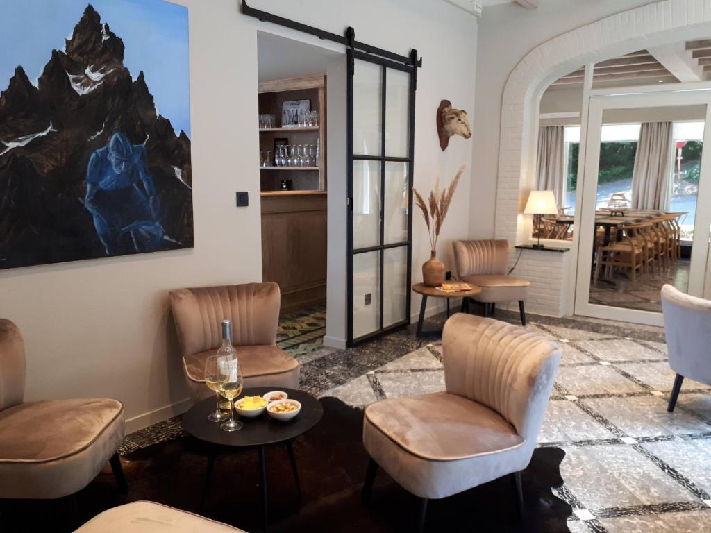 a living room with chairs and a table at Chalet Du Mont in Ruien