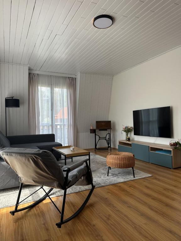 a living room with a couch and a tv at CHATA u BABULŮ in Morávka