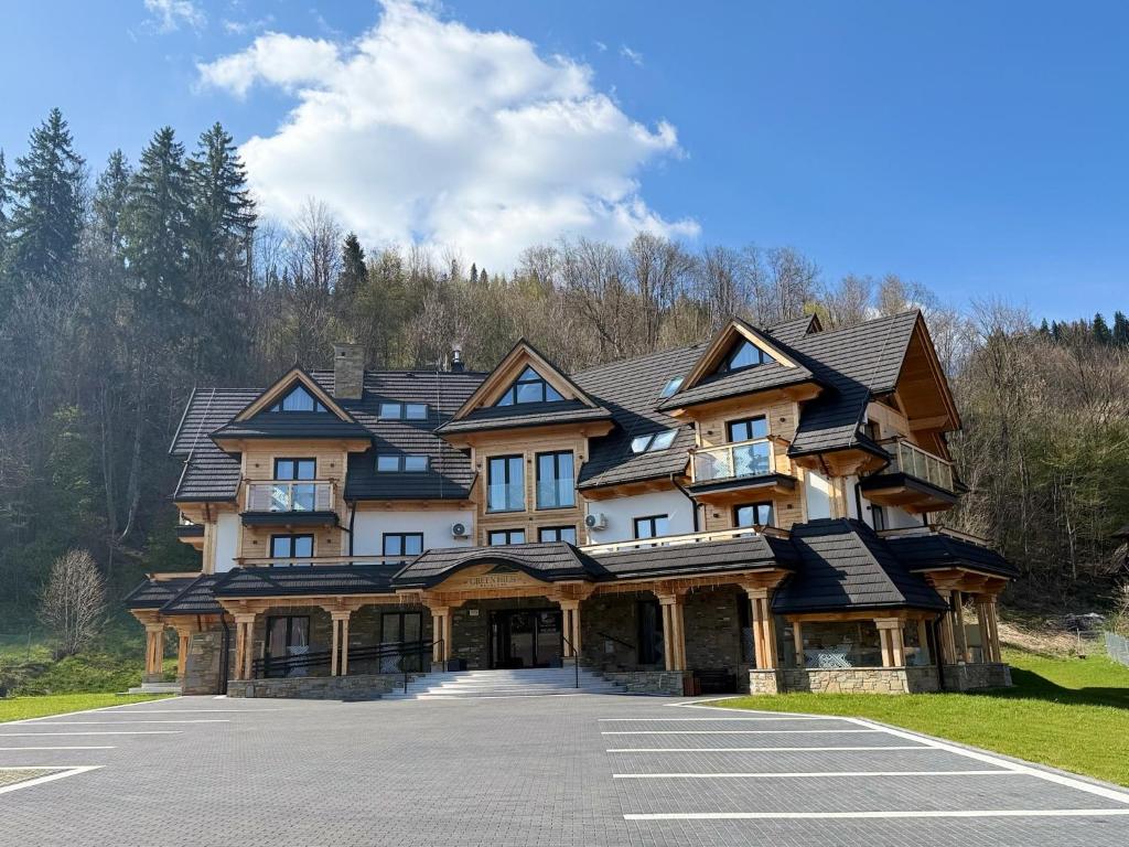 a large wooden house with a parking lot at GreenHill Bachleda in Zakopane