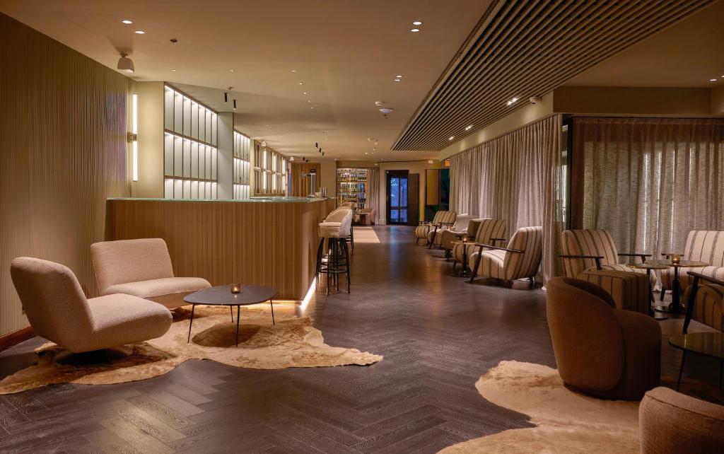 a waiting room with chairs and tables and a bar at Casa Serras Andorra in Andorra la Vella