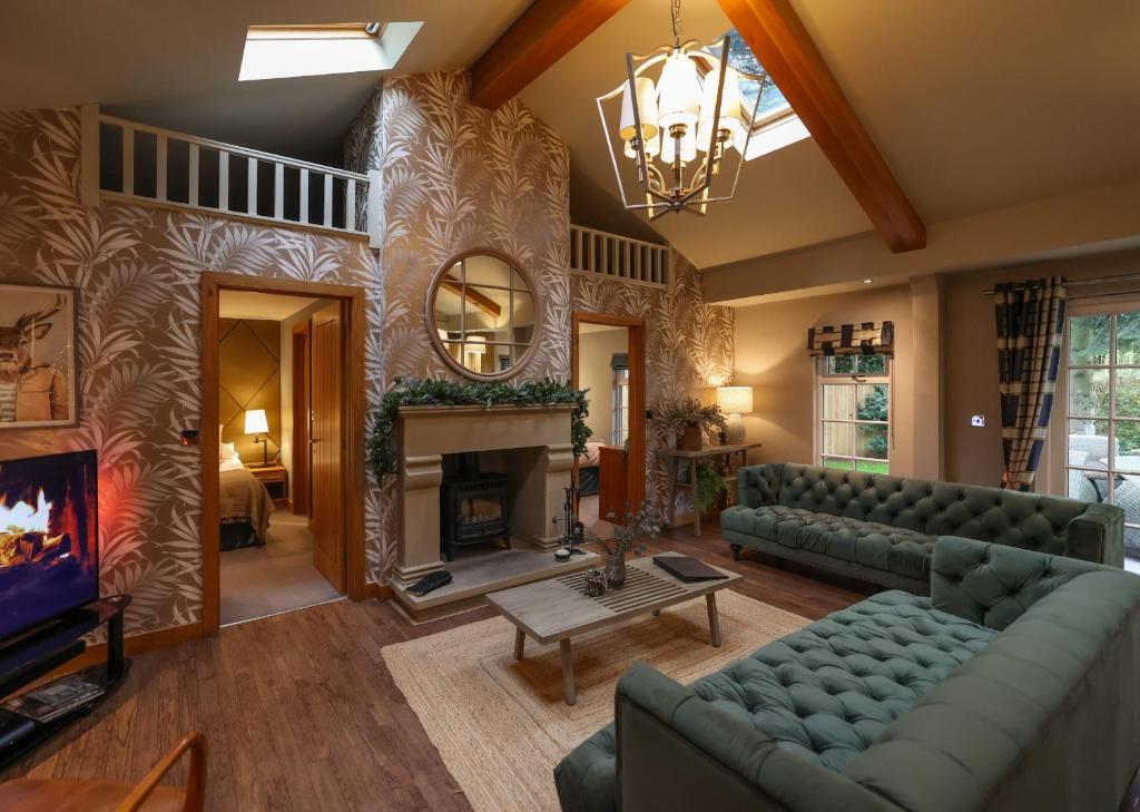 a living room with a couch and a fireplace at Grand Fir Lodge - The Hollies Retreats in Tarporley