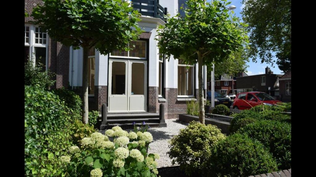 a house with trees and bushes in front of it at The Velvet Suite Alkmaar in Alkmaar