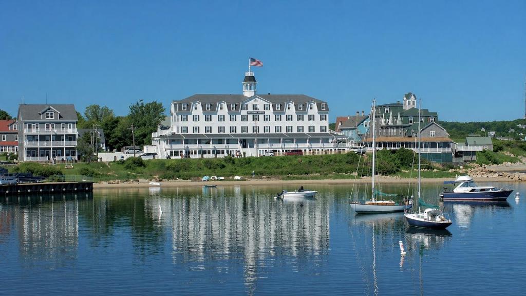 Eine Gruppe von Booten im Wasser vor einem großen Gebäude in der Unterkunft National Hotel in New Shoreham