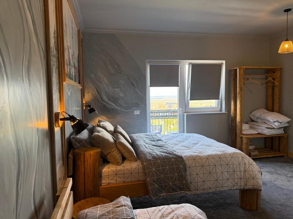 a bedroom with a bed and a window at GB Cazare in Volovăţ