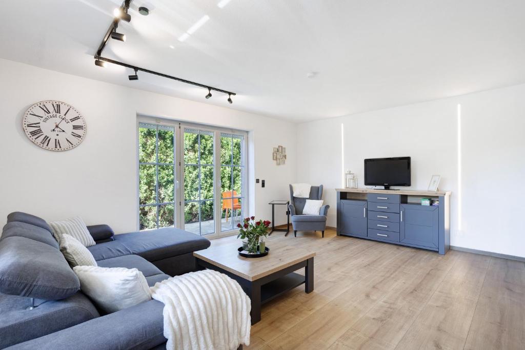 a living room with a blue couch and a tv at Feriennest Balve in Balve