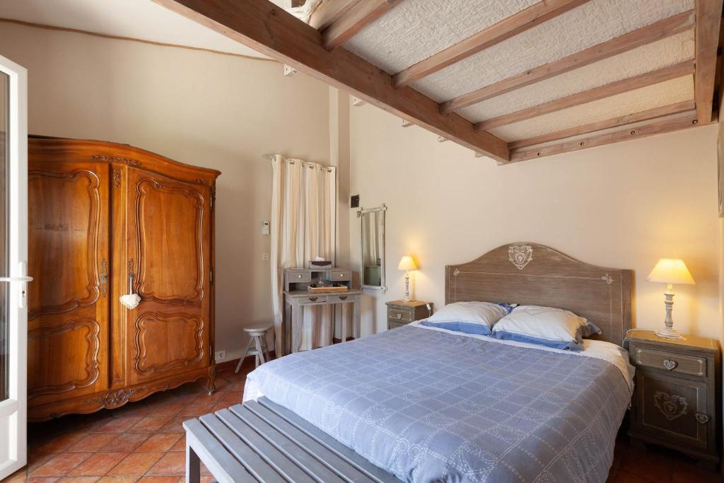 a bedroom with a blue bed and a wooden cabinet at Chambre D'hôtes Les 5 Calanques in Ensuès-la-Redonne