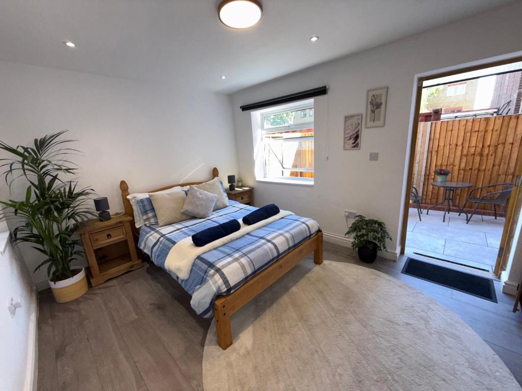 a bedroom with a bed and a table and a window at Entire Apartment Bright & Spacious with Private Garden Near Victoria Park in London