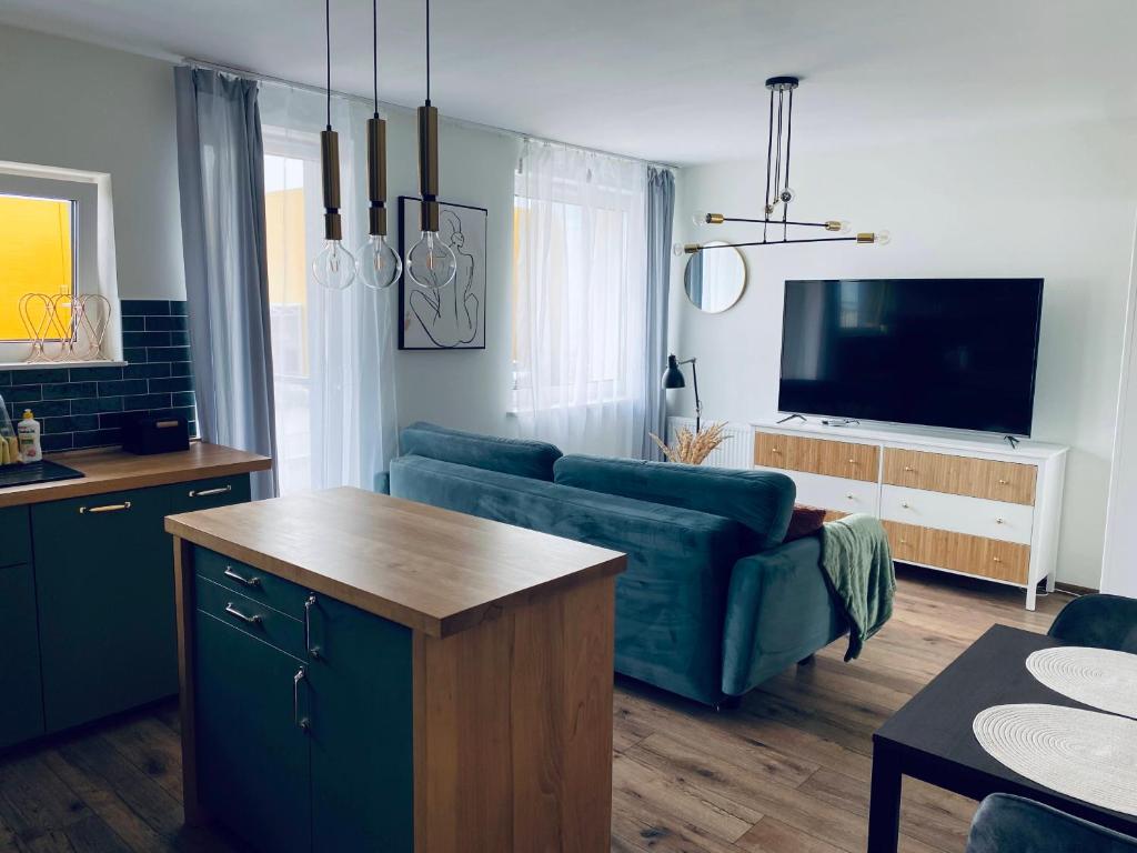 a living room with a blue couch and a tv at Apartament u Liska in Rumia