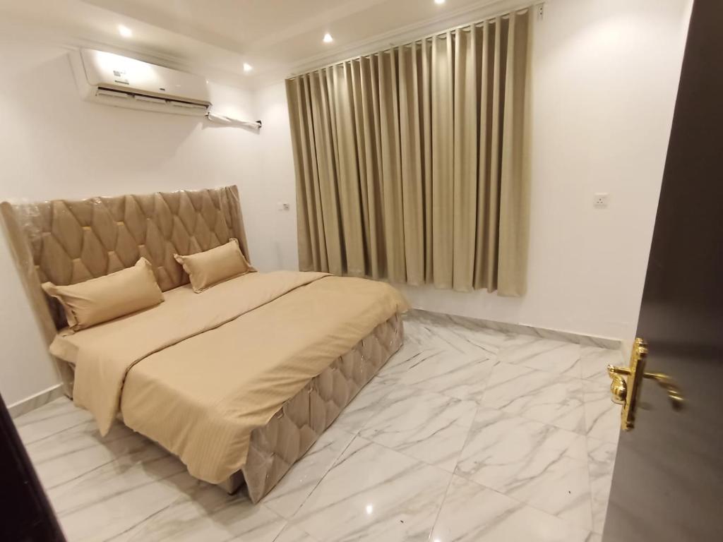 a bedroom with a large bed and a window at غرف عزاب وشقق عوايل in Riyadh