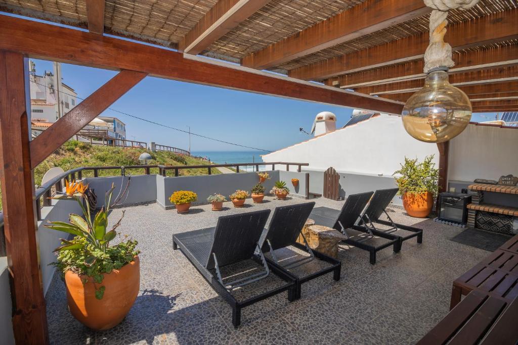 a patio with chairs and a table on a balcony at Agapito's Houses in Praia de Odeceixe
