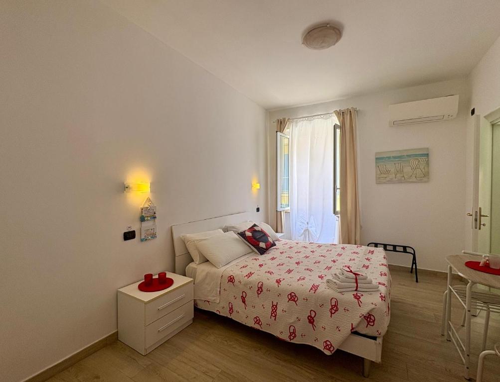 a white bedroom with a bed and a table at Affittacamere Il Veliero in Levanto