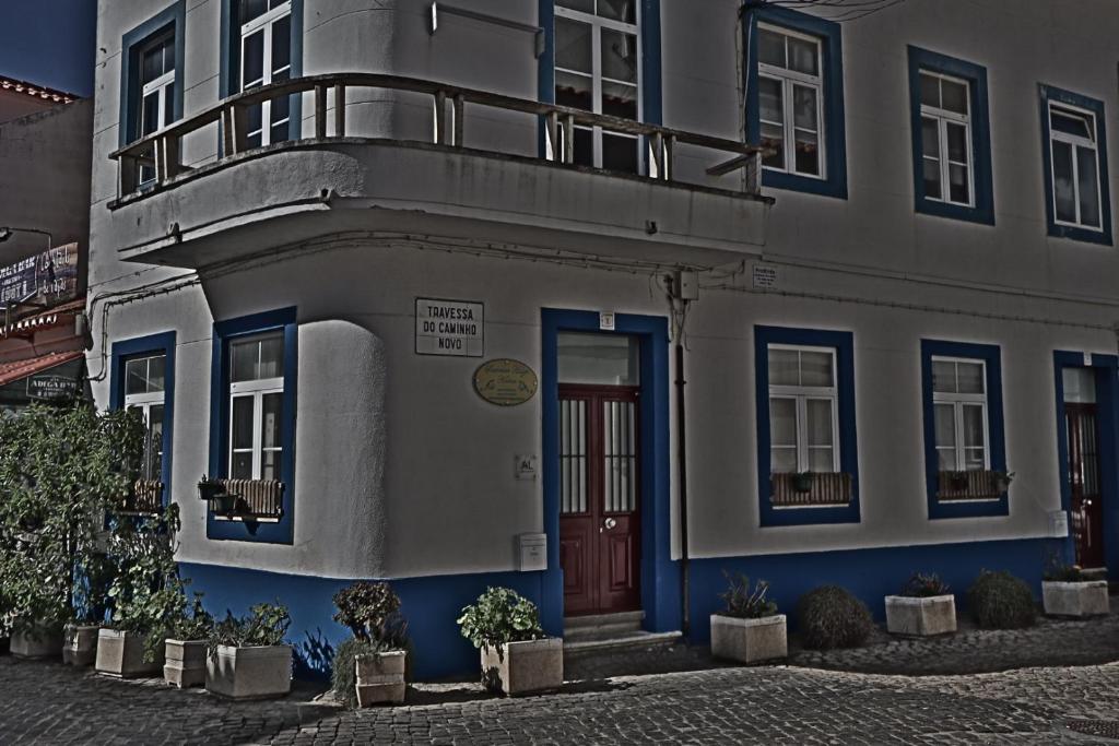 a white and blue building with a red door at Summer Haze Ericeira in Ericeira