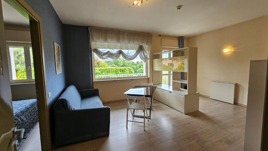 a living room with a chair and a table and a window at Hotel Residence Juvarra Centro Benessere in Biella