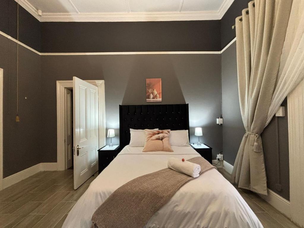 una camera da letto con un letto grande con cuscini rosa sopra di Bright Diamond Inn a Kimberley