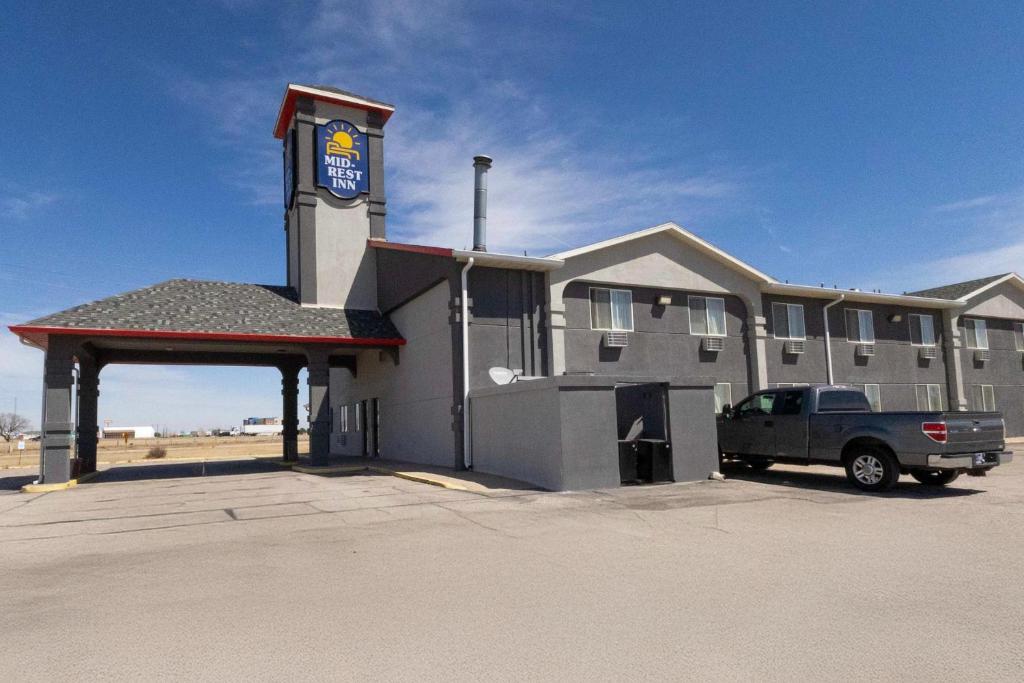 a building with a truck parked in front of it at Mid Rest Inn Lexington NE I-80 in Lexington
