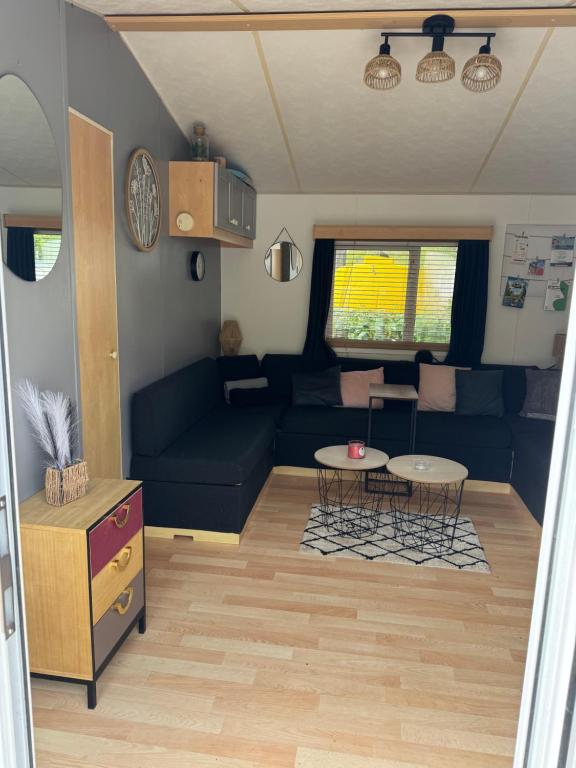 a living room with a couch and a table at Camping paradis in Clohars-Carnoët