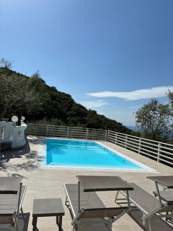 a swimming pool with two chairs and a table at Tenuta Camporosso in Massa Lubrense
