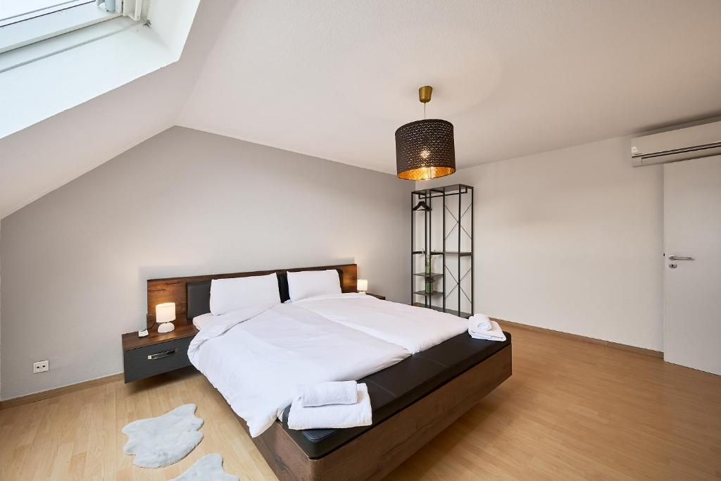 a bedroom with a large bed with white sheets at SANO - Hagen - Hegel in Hagen
