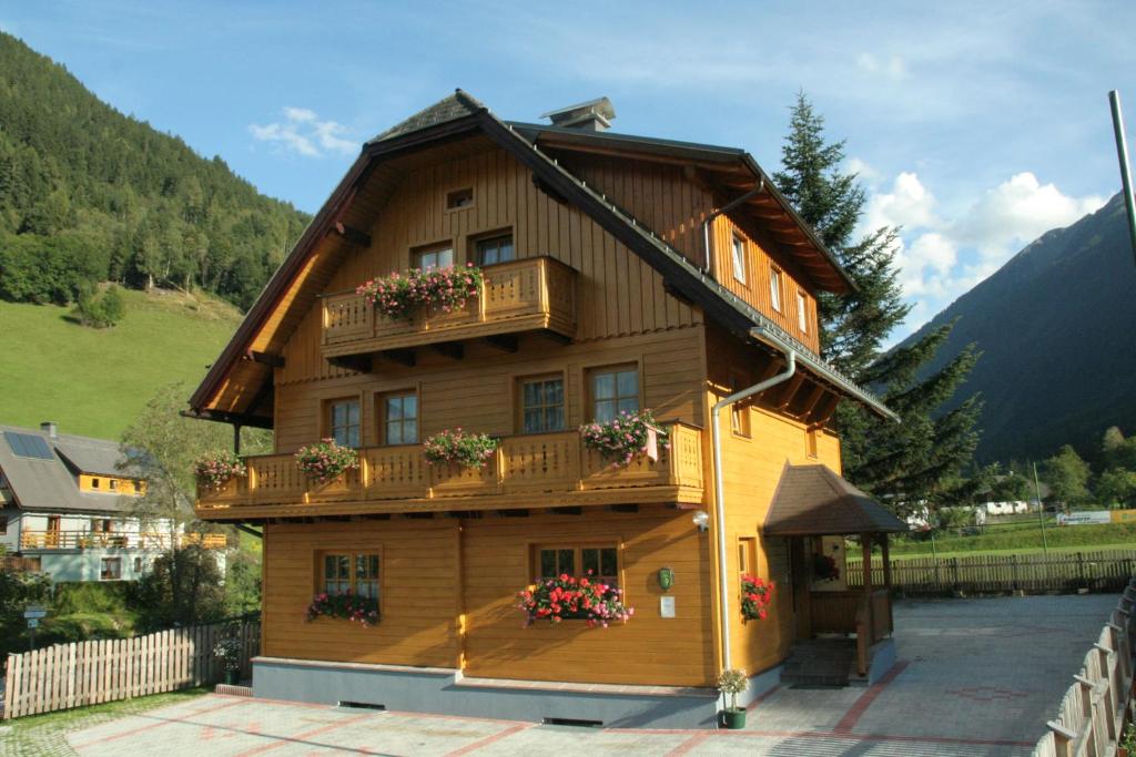 a wooden house with balconies and flowers on it at Appartementhaus Knaus in Schladming