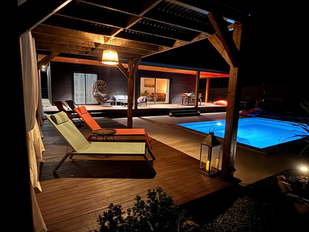 a backyard with a swimming pool and a deck with chairs at Villas Vallée d'ASCO in Moltifao