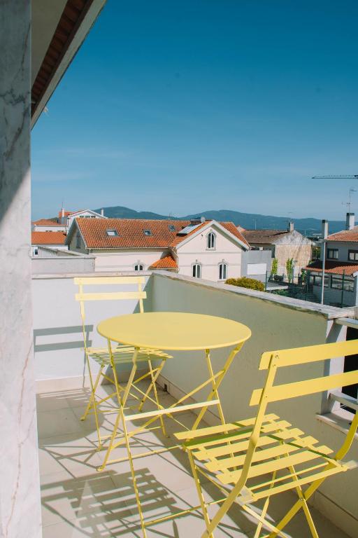 a yellow table and two chairs on a balcony at Just Like Home - Retorta do Pico in Caminha