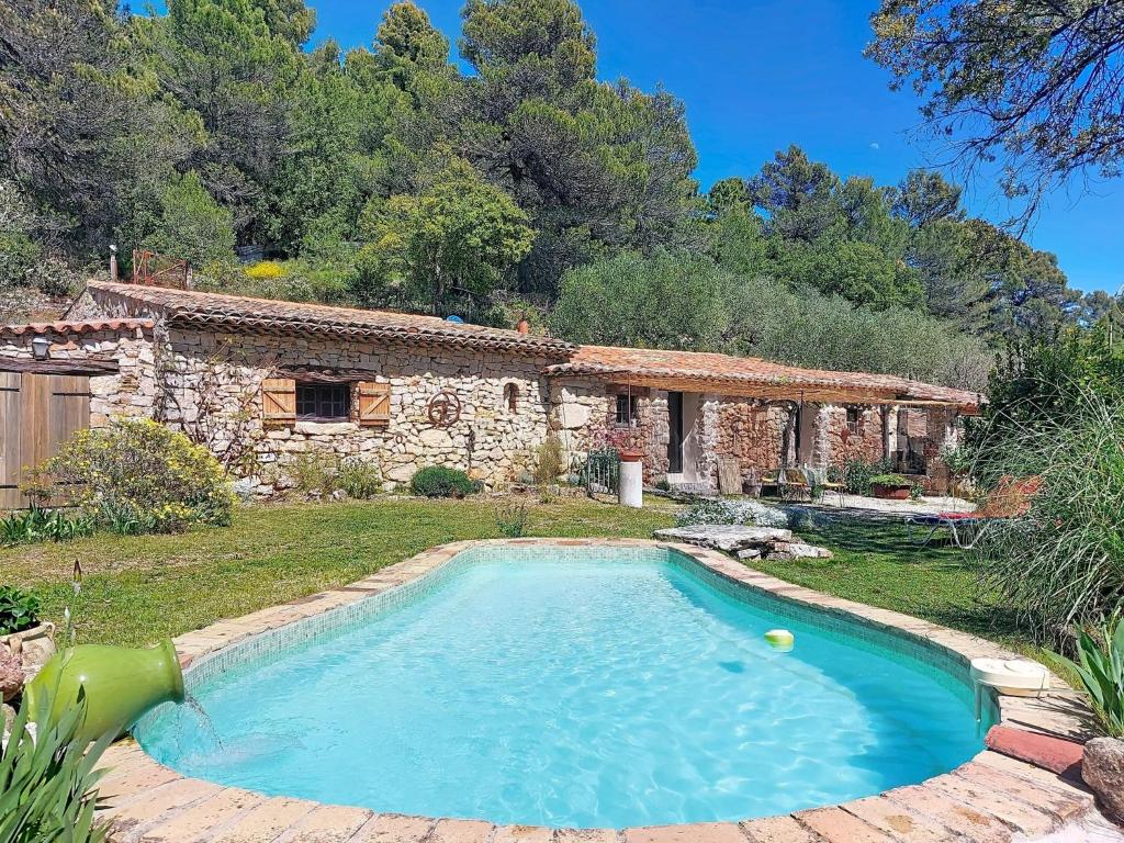 a swimming pool in front of a stone house at Holiday Home Chez Canard by Interhome in Ampus