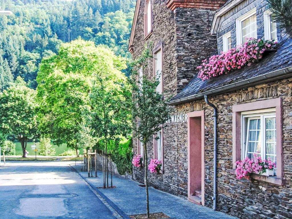 a stone building with pink flowers on the windows at Holiday Home Moselhäuschen by Interhome in Traben-Trarbach