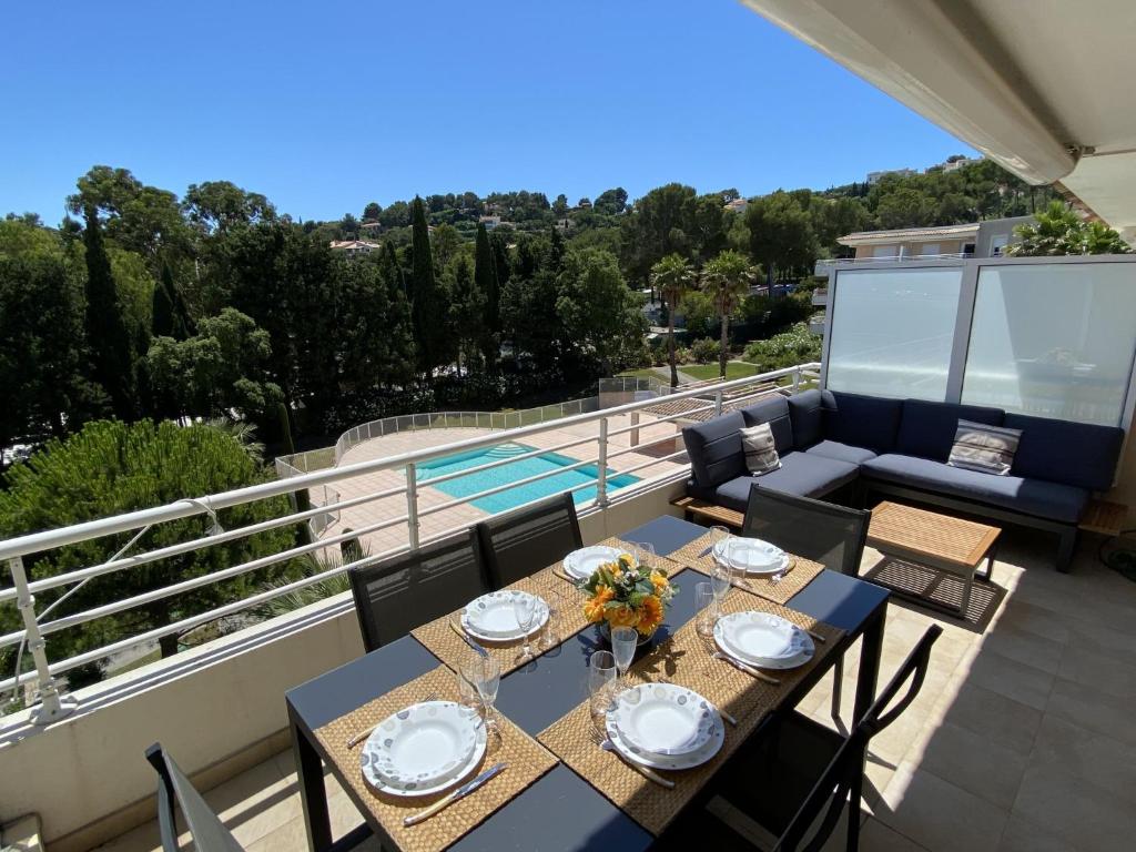a patio with a table and chairs on a balcony at Apartment Le Domaine de la Baie-1 by Interhome in Cavalaire-sur-Mer