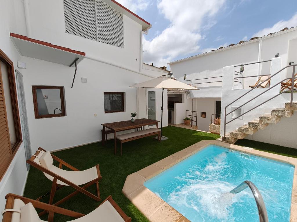 a backyard with a swimming pool and a house at Ca Na Margalida in Muro