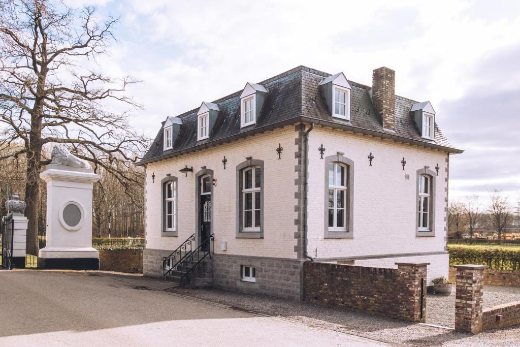 a white house with a black roof at Portierswoning Vaeshartelt in Maastricht