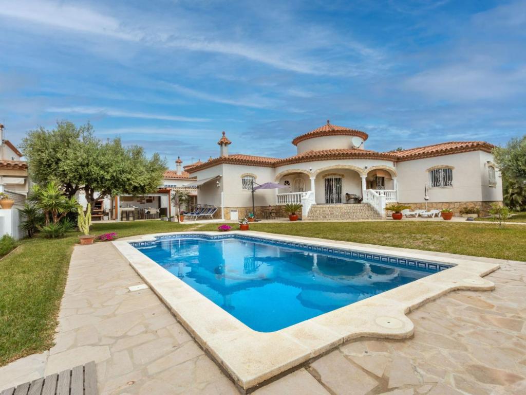 a villa with a swimming pool in front of a house at Villa Mys by Interhome in Miami Platja