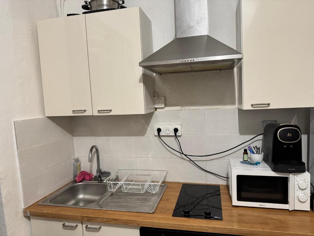 a kitchen with a sink and a microwave at Demane-bebbih in Étouars
