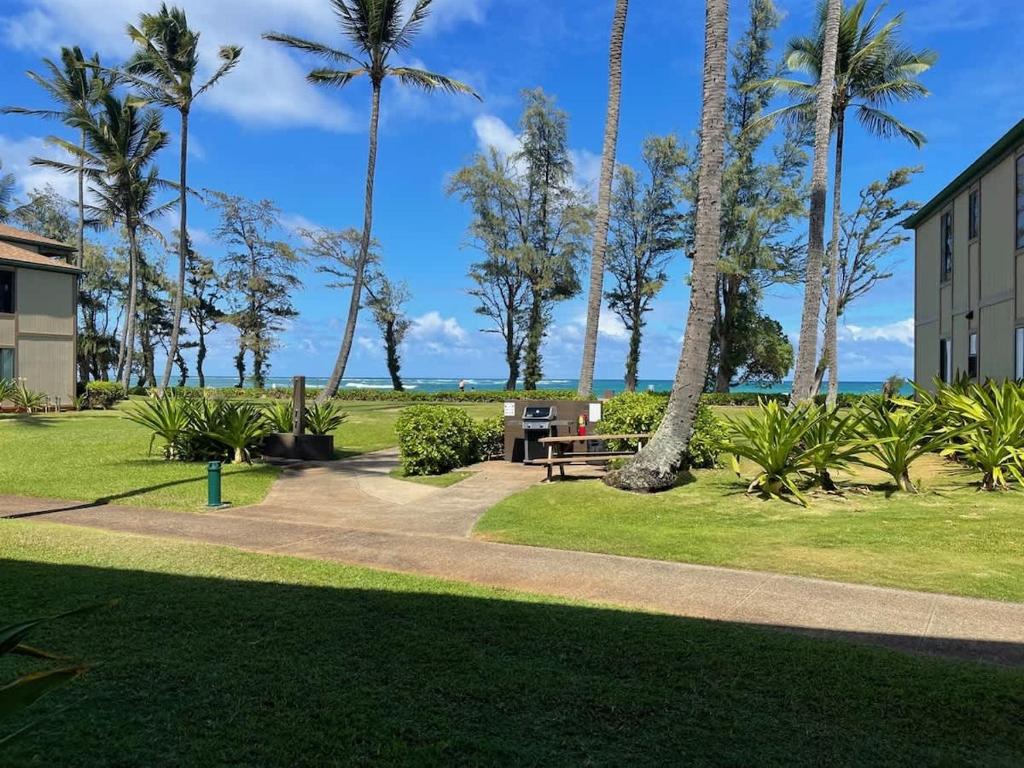 a park with palm trees and a picnic table at Ocean View Condo Pono Kai Resort PF-G102 in Kapaa
