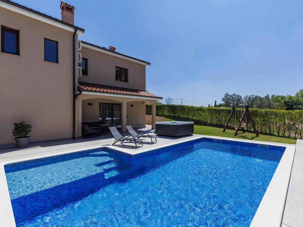 a villa with a swimming pool in front of a house at Apartment Eroa by Interhome in Žminj