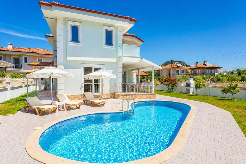 a villa with a swimming pool in front of a house at Villa Veli in Dalyan