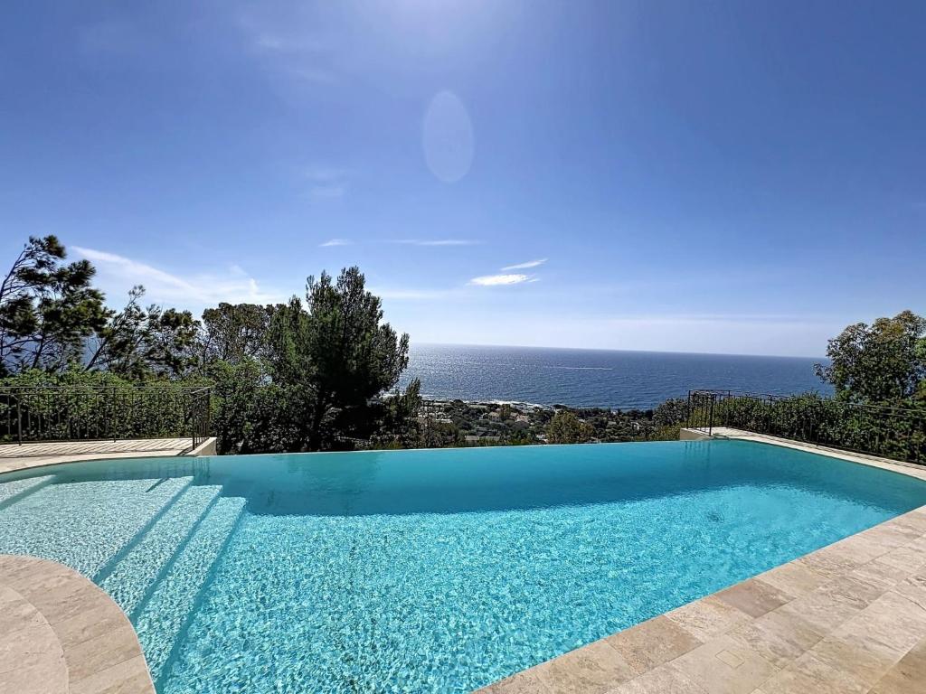 a swimming pool with a view of the ocean at Villa Odyssee by Interhome in Les Issambres