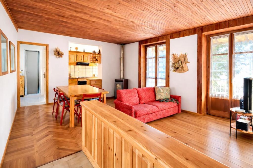 a living room with a red couch and a table at Appartamento Alta Valle Maira - Nebin in Villaro