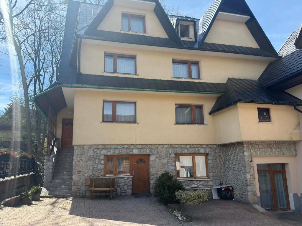 a large house with a gambrel roof at Domek Przy Potoku in Biały Dunajec