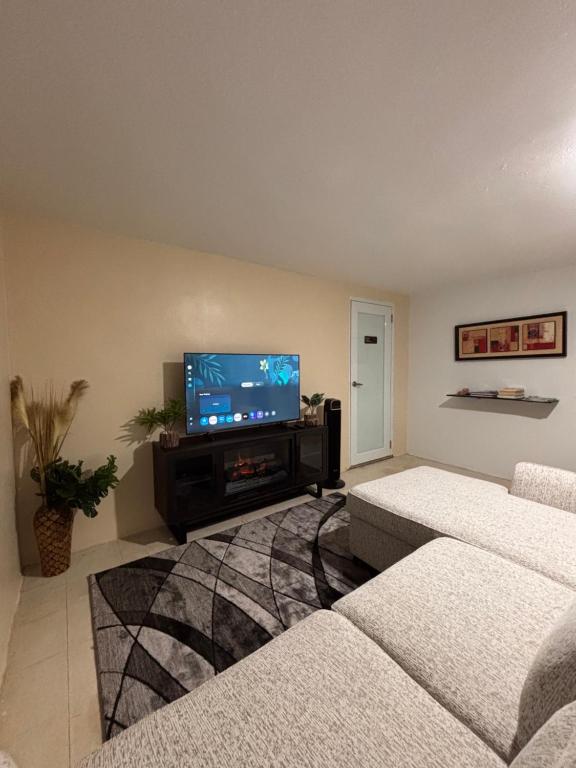 a living room with two couches and a flat screen tv at Casa Campo Vieques PR in Vieques