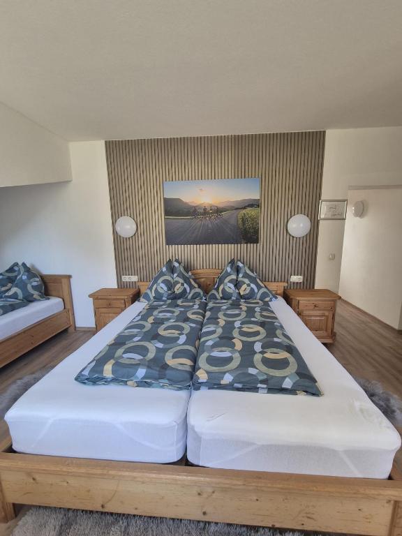 a bedroom with a large bed with blue pillows at Pyhrn Alps Inn "24h Self-Check-in-Hotel" in Spital am Pyhrn