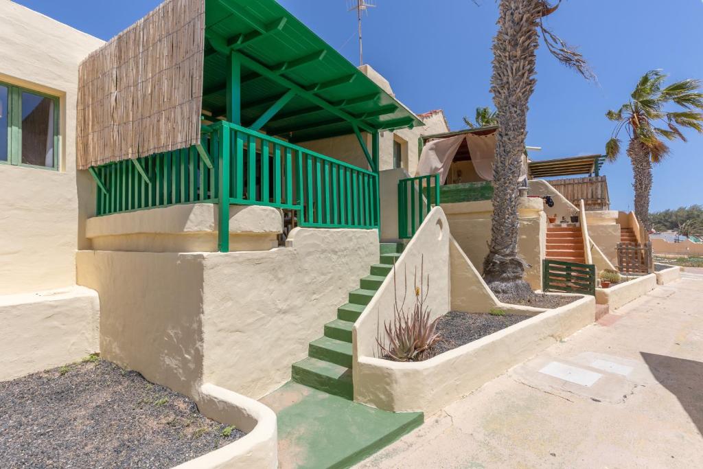 a house with stairs and a green railing at Casita Darmelo in Costa Calma