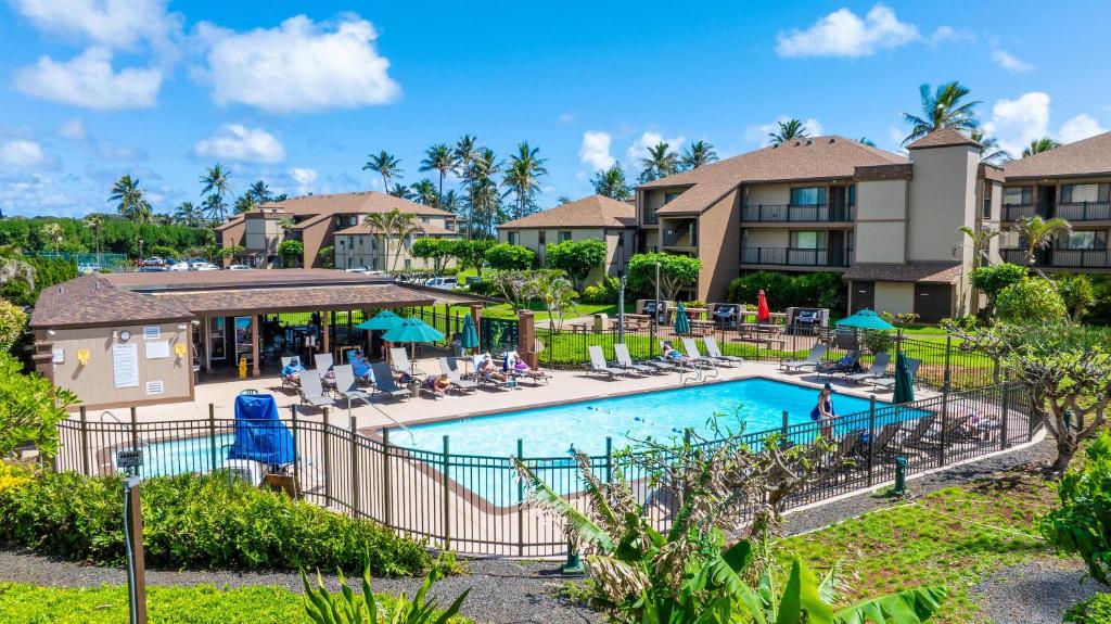 a pool at a resort with chairs and umbrellas at Kauai Serenity Condo Pono Kai Resort E206 in Kapaa