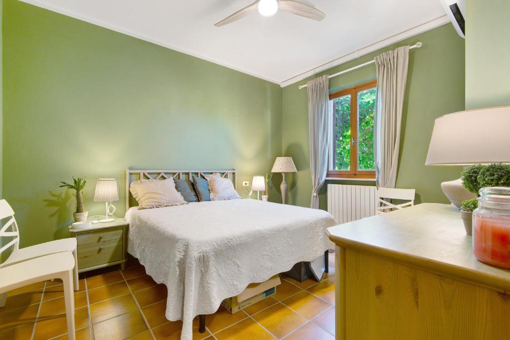 a green bedroom with a bed and a desk at Pino Vallegrande in Procchio