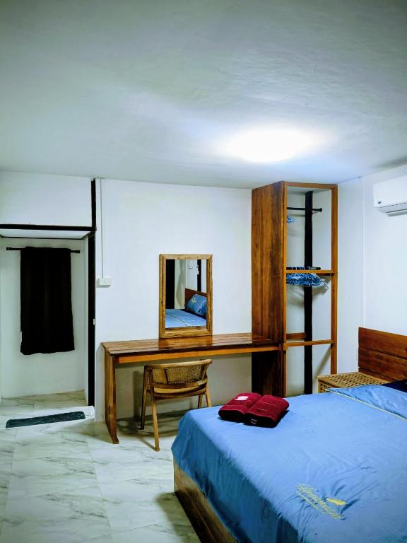 a bedroom with a bed and a desk and a mirror at Lake side villa in Ko Phangan