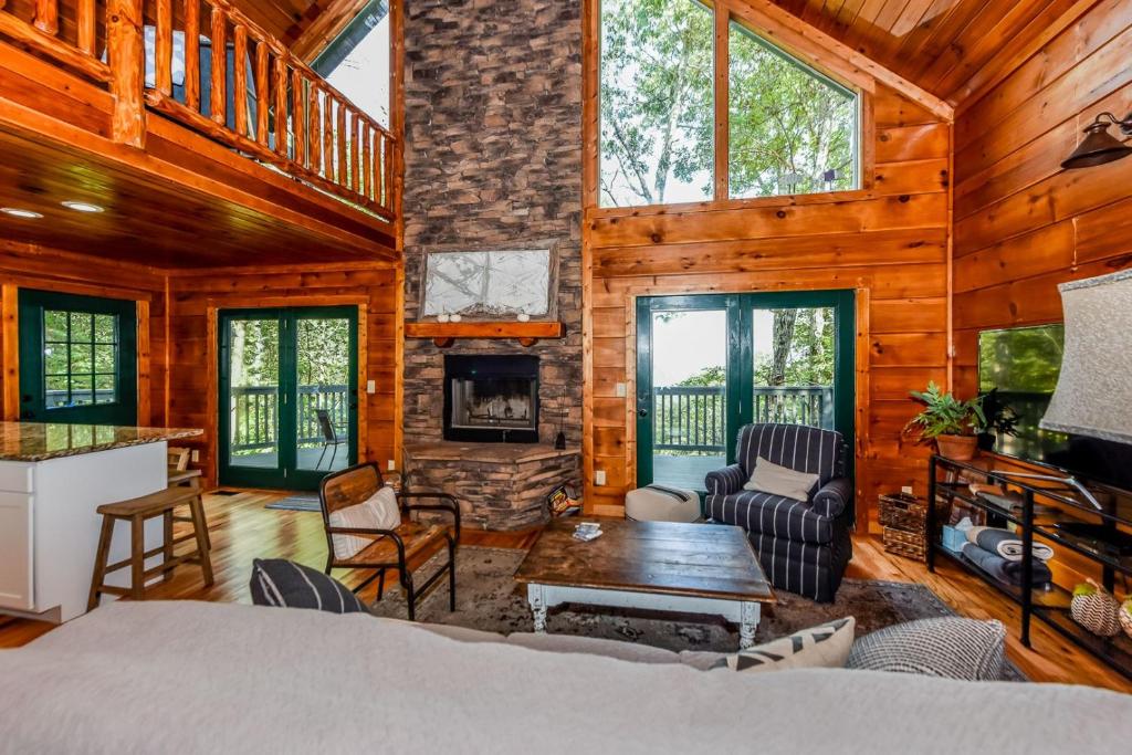 a log cabin with a living room and a fireplace at Tree Tops in Townsend