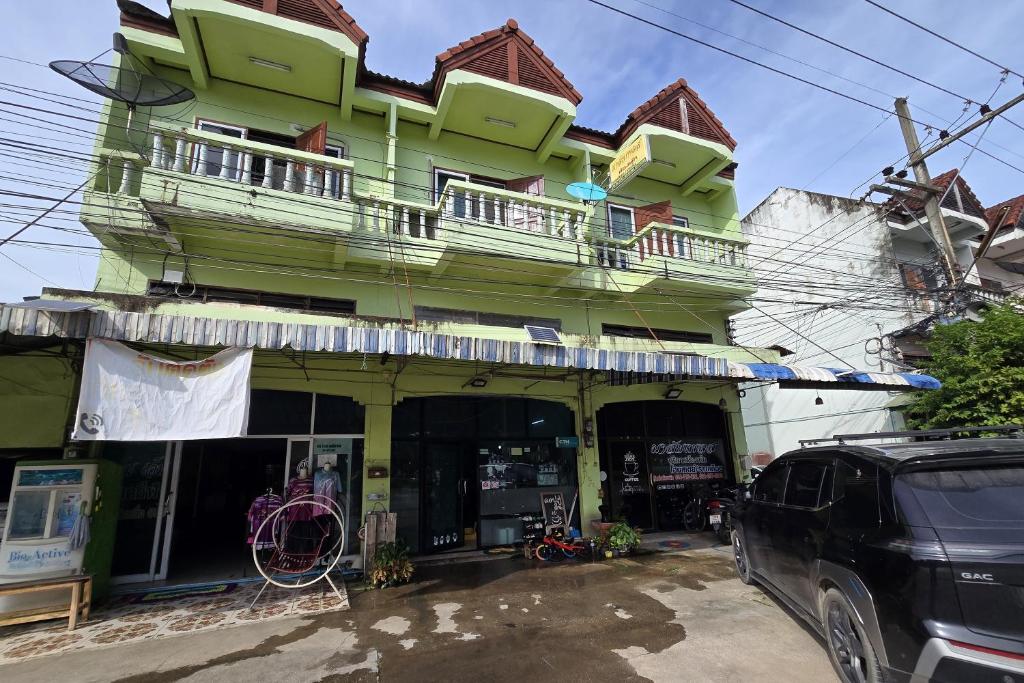 a green building with a balcony on top of it at Malai Place Lampang in Lampang
