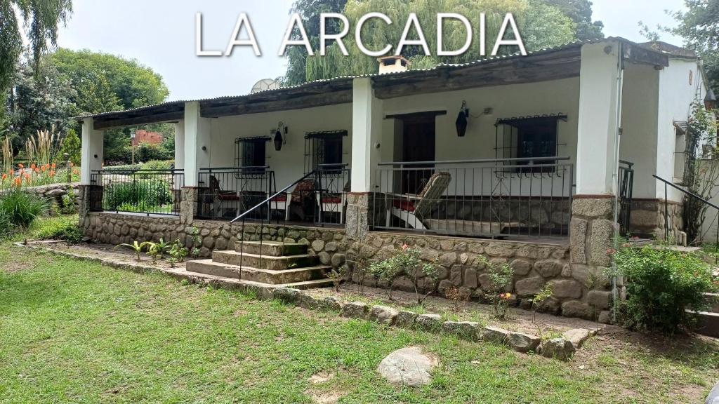 a house with a stone wall in front of it at La Arcadia in Tafí del Valle